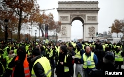 Protesters wearing yellow vests, a symbol of a French drivers' protest against higher fuel prices, block the Champs-Elysee in Paris, Nov. 24, 2018.