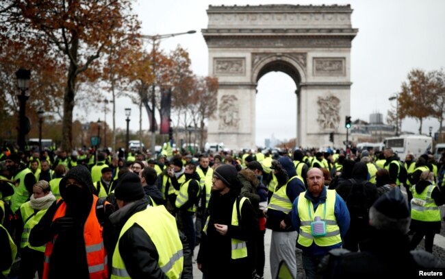 Protesters wearing yellow vests, a symbol of a French drivers' protest against higher fuel prices, block the Champs-Elysee in Paris, Nov. 24, 2018.