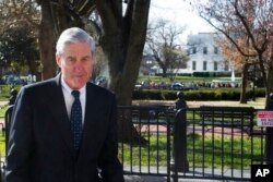 FILE - Special Counsel Robert Mueller walks past the White House, March 24, 2019.