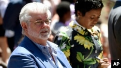 FILE - Filmmaker George Lucas, left, and his wife, Mellody Hobson, listen to remarks at a news conference outside Los Angeles City Hall, June 27, 2017. 