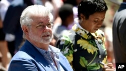 Filmmaker George Lucas, left, and his wife, Mellody Hobson, listen to remarks at a news conference outside Los Angeles City Hall, June 27, 2017. The Los Angeles City Council approved preliminary steps that will allow construction of the $1.5 billion Lucas Museum of Narrative Art in Exposition Park in Los Angeles.