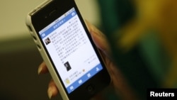 一名中國婦女在北京將微博下載到她的手機。