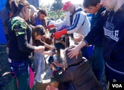 People gather at one of the few water taps at the Idomeni refugee camp in Greece, for more than 13,000 refugees, in March 2016.