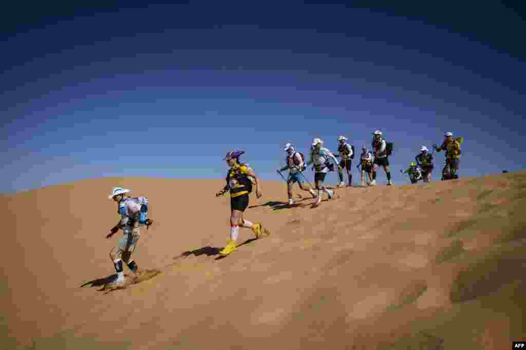 People compete in the stage 2 of the 34th edition of the Marathon des Sables between Tisserdimine and Kourci Dial Zaid in the southern Moroccan Sahara desert.