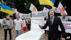 FILE - Anti-corruption activists hold a rally outside parliament in Kyiv, Ukraine, June 15, 2015. The rally organizers put a toilet seat on display as a symbol of what they feel is the effort by top officials to flush away politically inconvenient corruption cases.