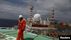 FILE - A worker walks on the heliport at the Brazil's Petrobras P-66 oil rig in the offshore Santos basin in Rio de Janeiro, Brazil, Sept. 5, 2018.