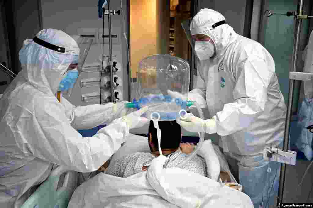 Medical staff members help a patient to wear a new non-invasive technology that can reduce the need of intubation at Covid-19 intensive care unit (ICU) at The Institute of Clinical Cardiology (ICC) in Rome, Italy.