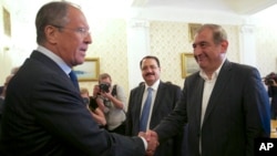 Russian Foreign Minister Sergei Lavrov, left, greets Syrian Deputy Prime Minister Qadri Jamil, right, in Moscow, Russia, July 22, 2013.