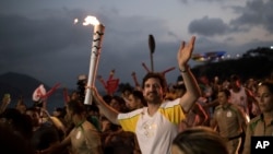 Leonardo Espindola carries the Olympic torch on its way to Rio de Janeiro for the opening ceremony of Rio's 2016 Summer Olympics, in Niteroi, Brazil on Aug. 2, 2016