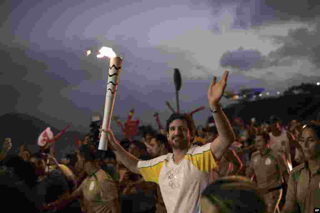 Leonardo Espindola carries the Olympic torch on its way to Rio de Janeiro for the opening ceremony of Rio's 2016 Summer Olympics, in Niteroi, Brazil, Tuesday, Aug. 2, 2016. The three-month torch relay across Brazil will end at the opening ceremony on Aug. 5, in Maracana stadium. (AP Photo/Felipe Dana)