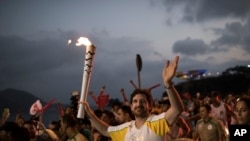 Leonardo Espindola akiwa ameshika mwenge wa Olimpiki kabla ya ufunguzi rasmi wa michezo hiyo Ijumaa tarehe 5 Julai mjini Rio de Janeiro, Brazil