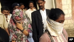 Face covered Shaheen Dhada, left, and Renu Srinivas, come out of a court in Mumbai, India after being arrested for their Facebook post, November 20, 2012.