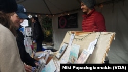 Artist Carlos Carmonamedina selling his postcards and prints at the Heinrich Christmas Market in downtown Washington.