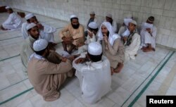 FILE - Pakistani religious students and teachers attend a discussion session at the Ganj Madrassa in Peshawar.