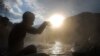 FILE - A Hindu devote offers prayers during a holy bath on the auspicious Makar Sankranti day at a natural hot water spring in Tattapani, about 52 kilometers (33 miles) north of Shimla, India.