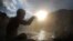 FILE - A Hindu devote offers prayers during a holy bath on the auspicious Makar Sankranti day at a natural hot water spring in Tattapani, about 52 kilometers (33 miles) north of Shimla, India.