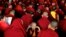 A novice Tibetan monk gestures to the camera as the spiritual leader the Dalai Lama delivers the Jangchup Lamrim teachings at the Sera Monastery in Bylakuppe, 135 miles west of Bangalore, India. 