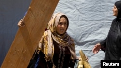 Syrian woman prepare to move their home at the request of the land owner at a refugee camp in the east Lebanese town of Anjar near the Syrian border, May 13, 2014. 