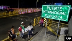 Miembros de una familia cruzan el Puente Internacional Rumichaca, en la frontera entre Ipiales en Colombia, y Tulcán en Ecuador, el 23 de agosto de 2018.