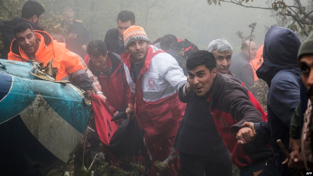 Rescuers recover bodies at the crash site of a helicopter transporting Iran's President, his Foreign Minister, and others in a fog-covered mountainous area of Varzaghan in northwestern Iran on May 20, 2024. (Photo by Azin HAGHIGHI / MOJ News Agency / AFP)