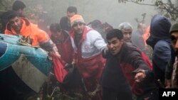 Rescuers recover bodies at the crash site of a helicopter transporting Iran's President, his Foreign Minister, and others in a fog-covered mountainous area of Varzaghan in northwestern Iran on May 20, 2024. (Photo by Azin HAGHIGHI / MOJ News Agency / AFP)