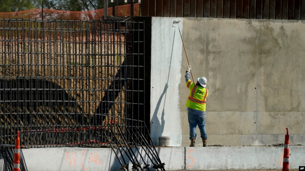 资料照片：一名建筑工人为德克萨斯州米逊的一段边界墙涂漆。(2020年11月16日)(photo:VOA)