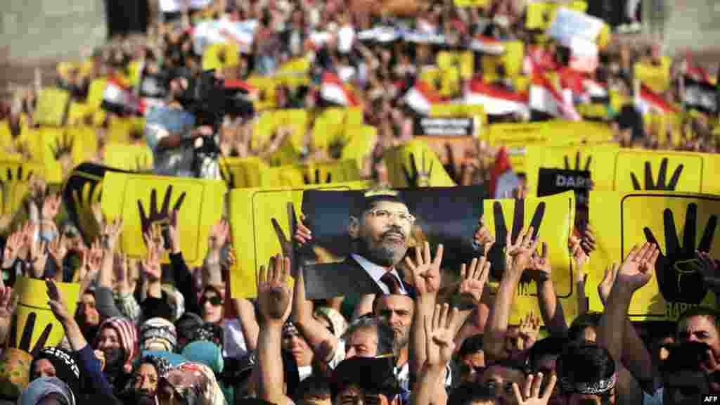 Protesters hold signs during a demonstration condemning the recent deadly military crackdown on supporters of ousted Egyptian President Mohamed Morsi in Cairo on August 17, 2013, at the New Mosque in Istanbul. 