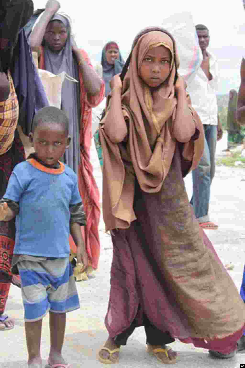 Children arriving with their belongings at a newly-established IDP camp in Mogadishu after a long trek from south-central Somalia. (VOA - P. Heinlein)