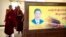 西藏拉萨一所寺庙的喇嘛走过习近平的画像屏风。（2021年5月31日）