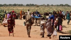 FILE - FILE PHOTO: Families escaping Ardamata in West Darfur cross into Adre, Chad, after a wave of ethnic violence, November 7, 2023. Survivors recounted executions and looting in Ardamata, which they said were carried out by RSF and allied Arab militias. 