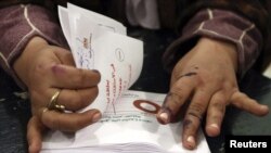 An official counts ballots after polls closed during the final stage of a referendum on Egypt's new constitution in Bani Sweif, about 115 km (71 miles) south of Cairo December 22, 2012.