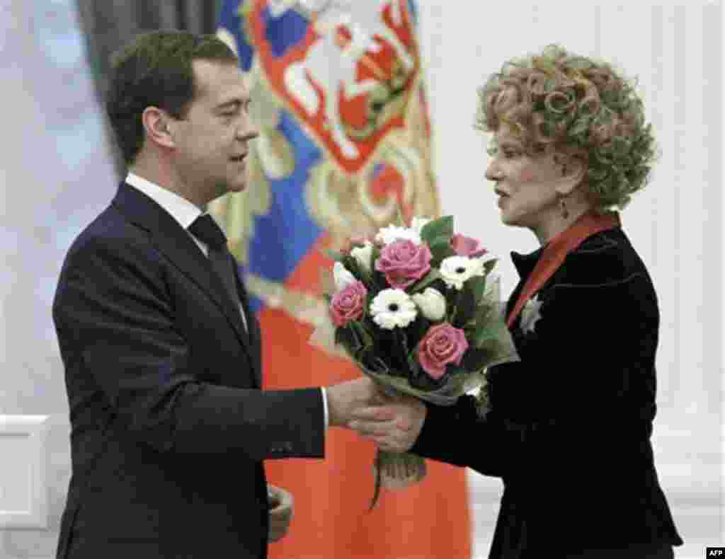 Russian President Dmitry Medvedev present a medal and flowers to actress Lyudmila Gurchenko during an awards ceremony at the Kremlin, Moscow, Thursday, Dec. 30, 2010. (AP Photo/RIA Novosti, Dmitry Astakhov, Presidential Press Service)