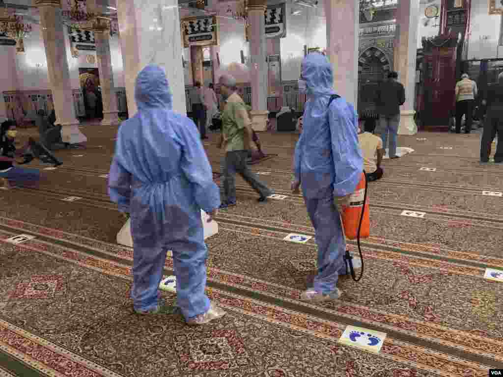 Between prayer sessions, mosque workers try to sanitize all mats and the prayer area to try to slow the spread of coronavirus, June 28, 2020. (Hamada Elrasam/VOA)