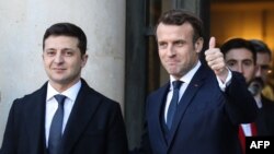 9일 우크라이나 내전을 끝내기 위한 협상이 프랑스 파리 엘리제궁에서 열린 가운데, 에마뉘엘 마크롱 프랑스 대통령(오른쪽)이 볼로디미르 젤렌스키 우크라이나 대통령을 환영하고 있다.