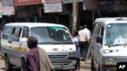 A man walks past two Kenyan minibuses in Nairobi.