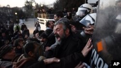Protesting farmers scuffle with riot police officers during a rally in the northern Greek city of Thessaloniki, Jan. 28, 2016.