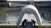 FILE - Kazumi Matsui, right, mayor of Hiroshima, bows at Hiroshima Memorial Cenotaph at the Hiroshima Peace Memorial Park in Hiroshima, western Japan, Aug. 6, 2015. 