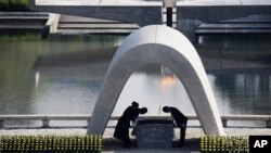 FILE - Kazumi Matsui, right, mayor of Hiroshima, bows at Hiroshima Memorial Cenotaph at the Hiroshima Peace Memorial Park in Hiroshima, western Japan, Aug. 6, 2015. 