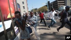 FILE - Protesters disperse in Harare Aug. 24, 2016, after Zimbabwe police fired tear gas, water cannon and gunshots to stop hundreds of youths rallying against the government of President Robert Mugabe.