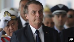 Brazil's President Jair Bolsonaro arrives for the inauguration ceremony of his new naval commander, Ilques Barbosa Junior, at the Naval Club in Brasilia, Jan. 9, 2019. 