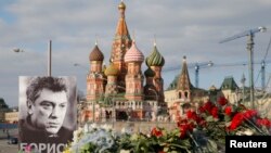 FILE - A portrait of Kremlin critic Boris Nemtsov and flowers are pictured at the site where he was killed on February 27, with St. Basil's Cathedral seen in the background, at the Great Moskvoretsky Bridge in central Moscow, March 6, 2015. 