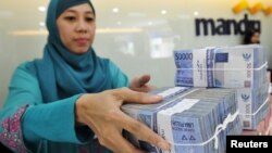 Kasir di kantor cabang Bank Mandiri sedang menghitung mata uang Rupiah di Jakarta, 20 Juli 2015. (Foto: Antara via Reuters)