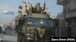 Di vê fotoya arşîvê de şervanên YPG serkeftina xwe pîroz dikin