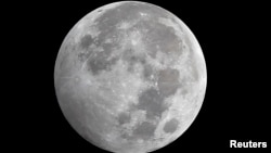 The Earth (unseen) casts a faint shadow over the southwestern part of a full moon during the penumbral lunar eclipse in Cairo October 19, 2013. A penumbral lunar eclipse occurs when the moon crosses the Earth's shadow, causing a slight dimming on the moon