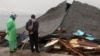 Warga melihat bangunan yang rusak di Ambon, Maluku, 27 September 2019. (Foto: AP)