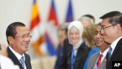 Le Premier ministre cambodgien Hun Sen, à gauche, sourit en saluant les observateurs internationaux pour les élections générales du 29 juillet, lors d'une réunion de bienvenue au Palais de la Paix, à Phnom Penh, au Cambodge, le 28 juillet 2018.