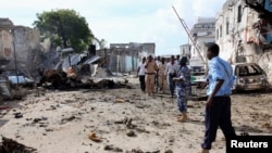 Somali police view the scene of a deadly blast in Mogadishu, April 14, 2013. 