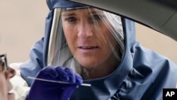 Una miembro de un equipo médico en Salt Lake, Utah, toma muestras a una persona para una prueba de COVID-19, el viernes 23 de agosto de 2020.