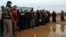 Newly arrived Syrian refugees wait their turn to receive mattresses, blankets and other supplies, and to be assigned to tents, at the Zaatari Syrian refugees camp in Mafraq, near the Syrian border with Jordan, Jan. 28, 2013.