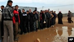 Newly arrived Syrian refugees wait their turn to receive mattresses, blankets and other supplies, and to be assigned to tents, at the Zaatari Syrian refugees camp in Mafraq, near the Syrian border with Jordan, Jan. 28, 2013.